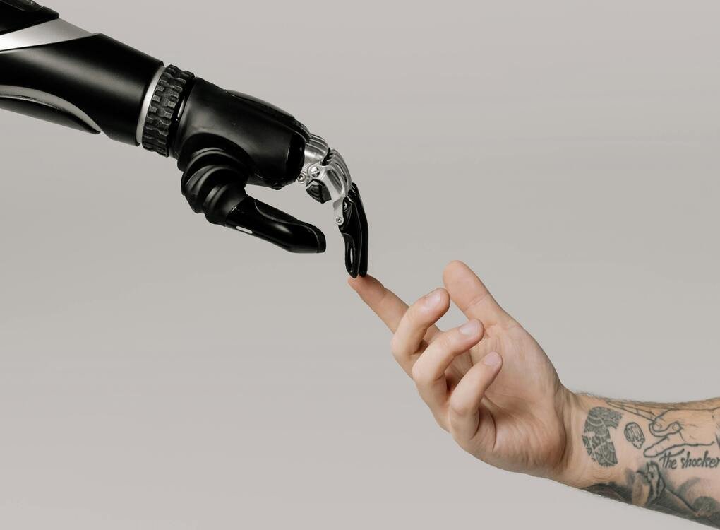 A robotic hand and a human hand reaching out to touch, symbolizing the role of open source generative AI applications for document extraction in connecting technology and humanity.