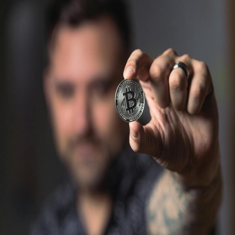 Person holding a Bitcoin coin, featured on ecrypto1.com crypto reviews for cryptocurrency insights