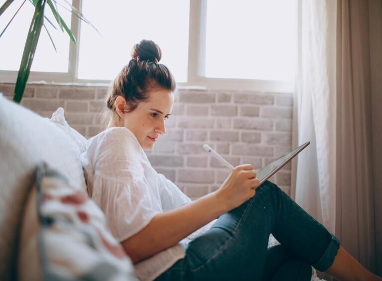 Young woman demonstrating tablet writing techniques on a couch for http://tabletwritings.com blog.