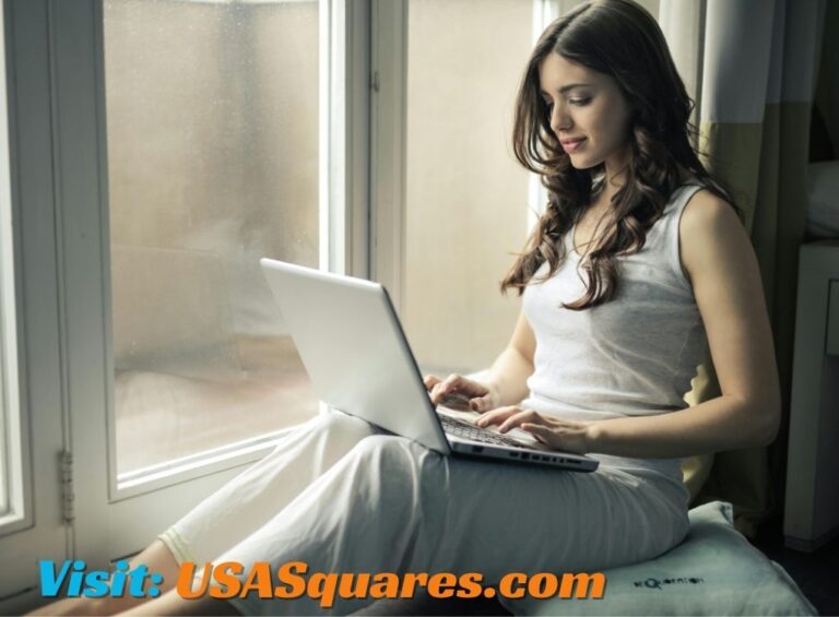 Woman using a laptop by the window, exploring Lillienu resources.