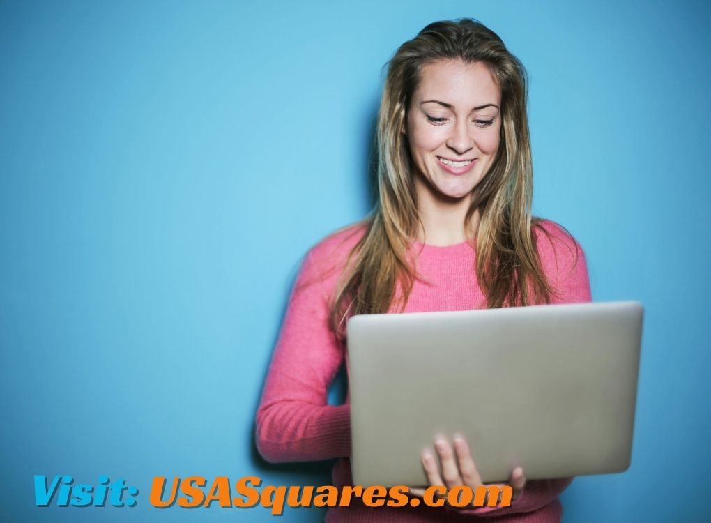 Smiling woman using a laptop, exploring Lillienu insights against a blue background.